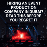 Hiring an event production company in Dubai – stage setup with LED screen and city skyline at night.